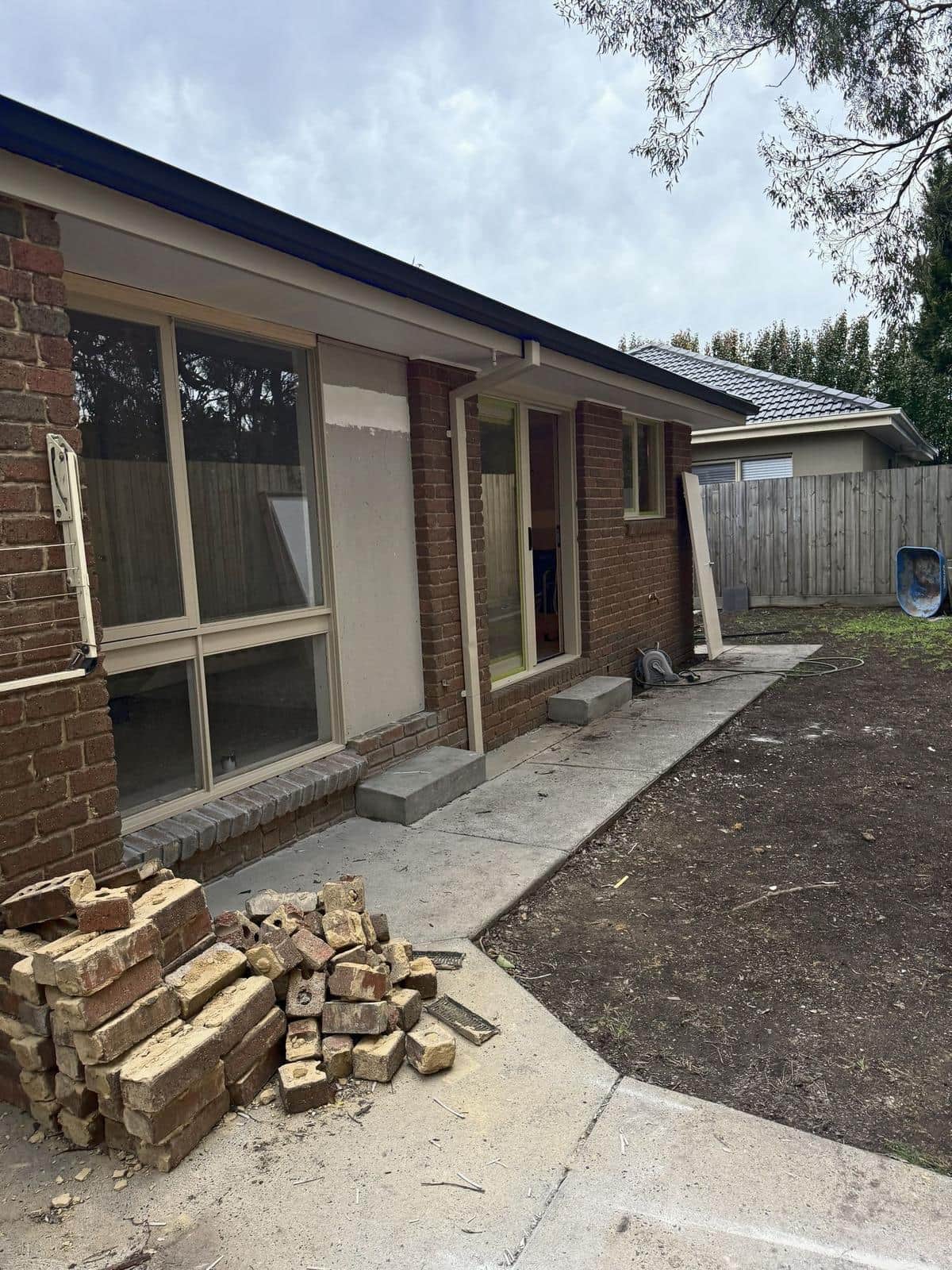 Back of the house with bare soil and stacked bricks, Forest Hill
