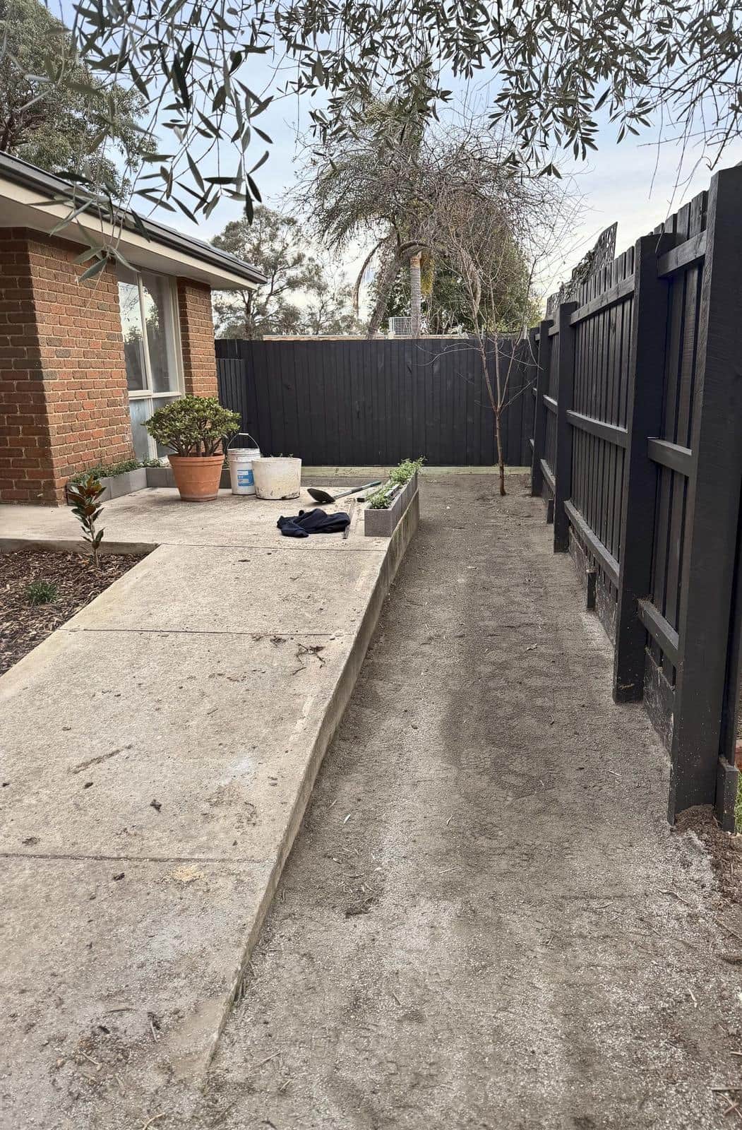 Side path beside a freshly painted charcoal fence, Forest Hill