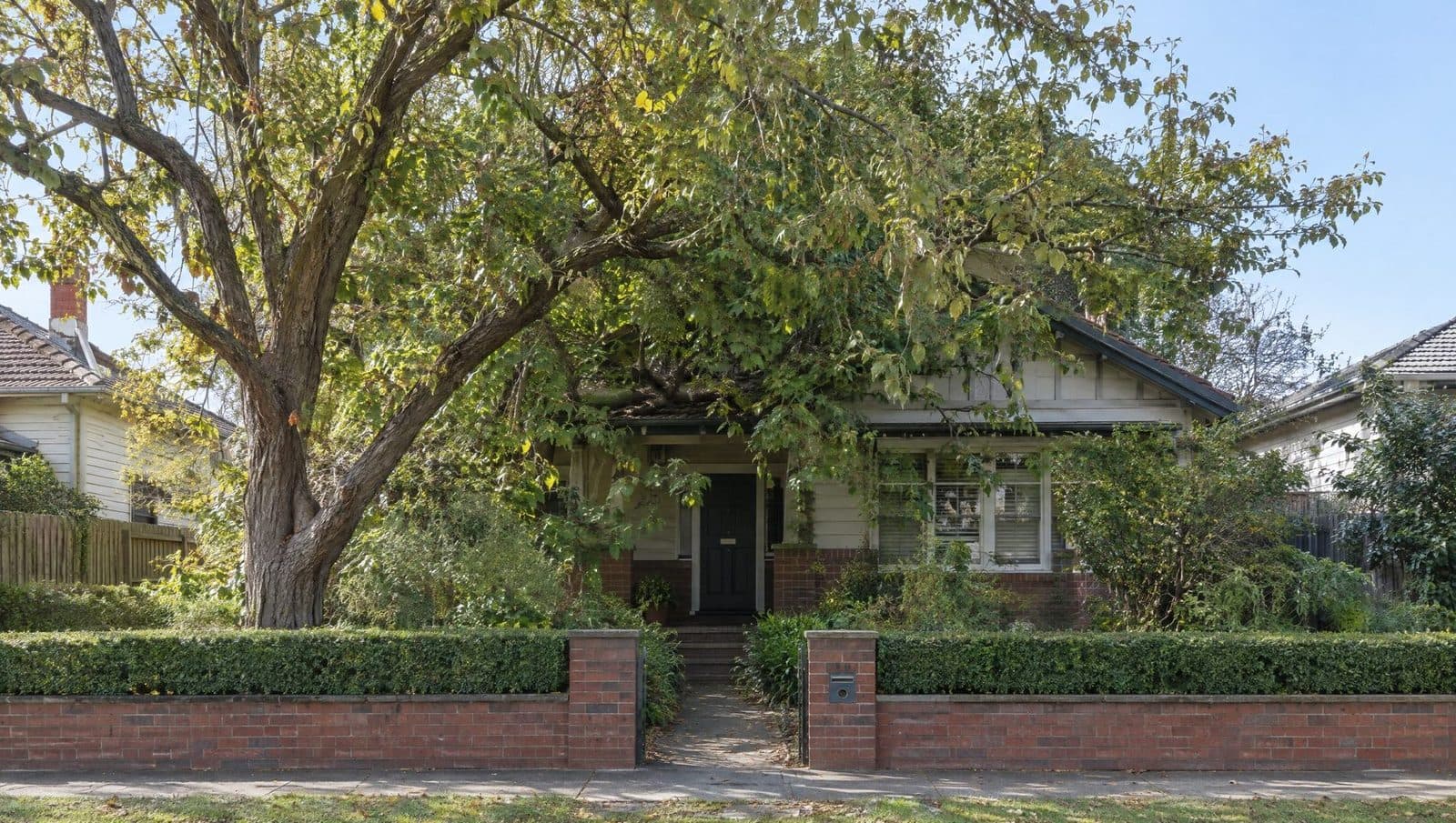 Before: a heavy, low canopy over the front of a brick bungalow