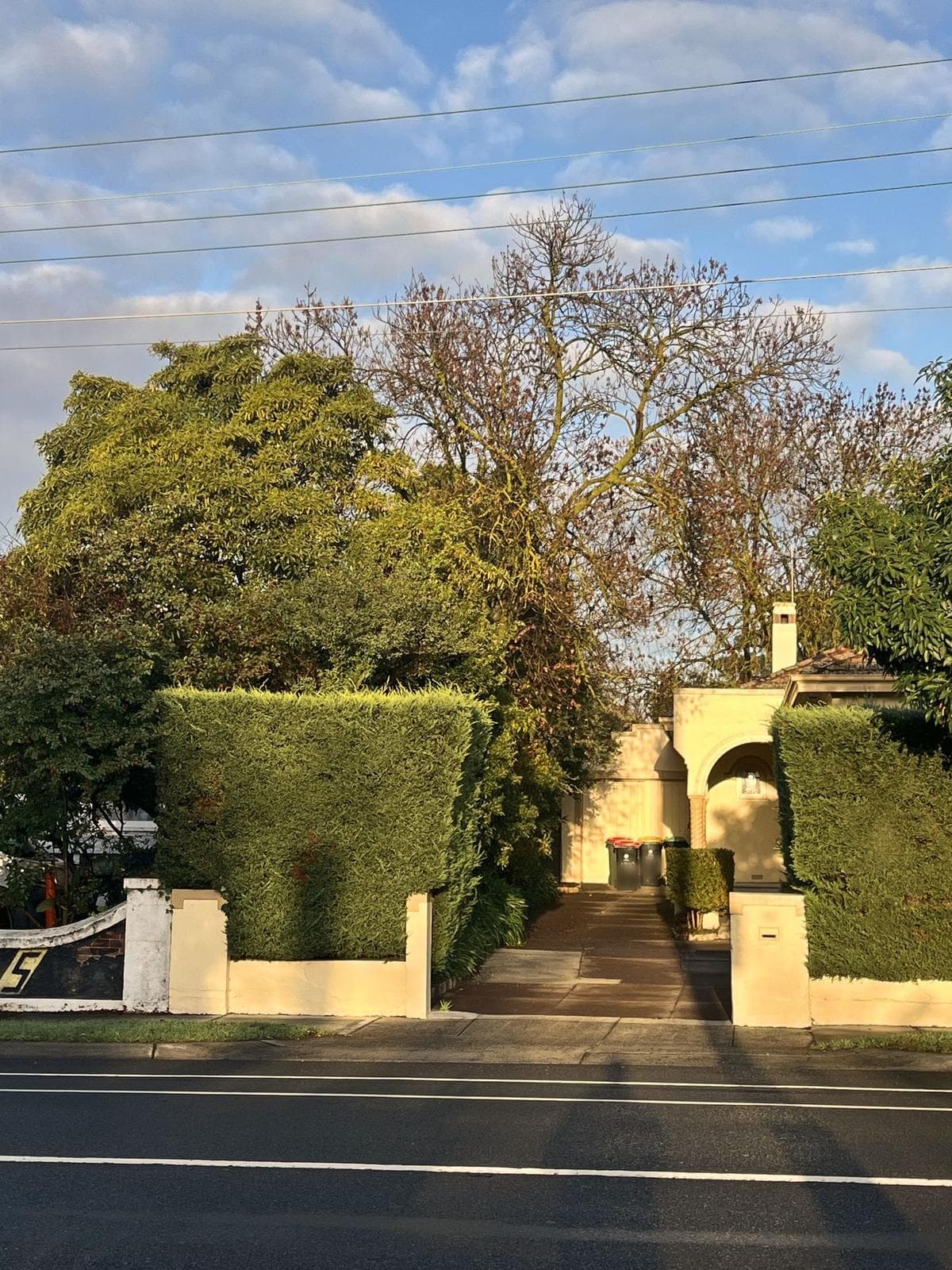 Clipped hedges framing the entry path of a commercial frontage, Malvern East