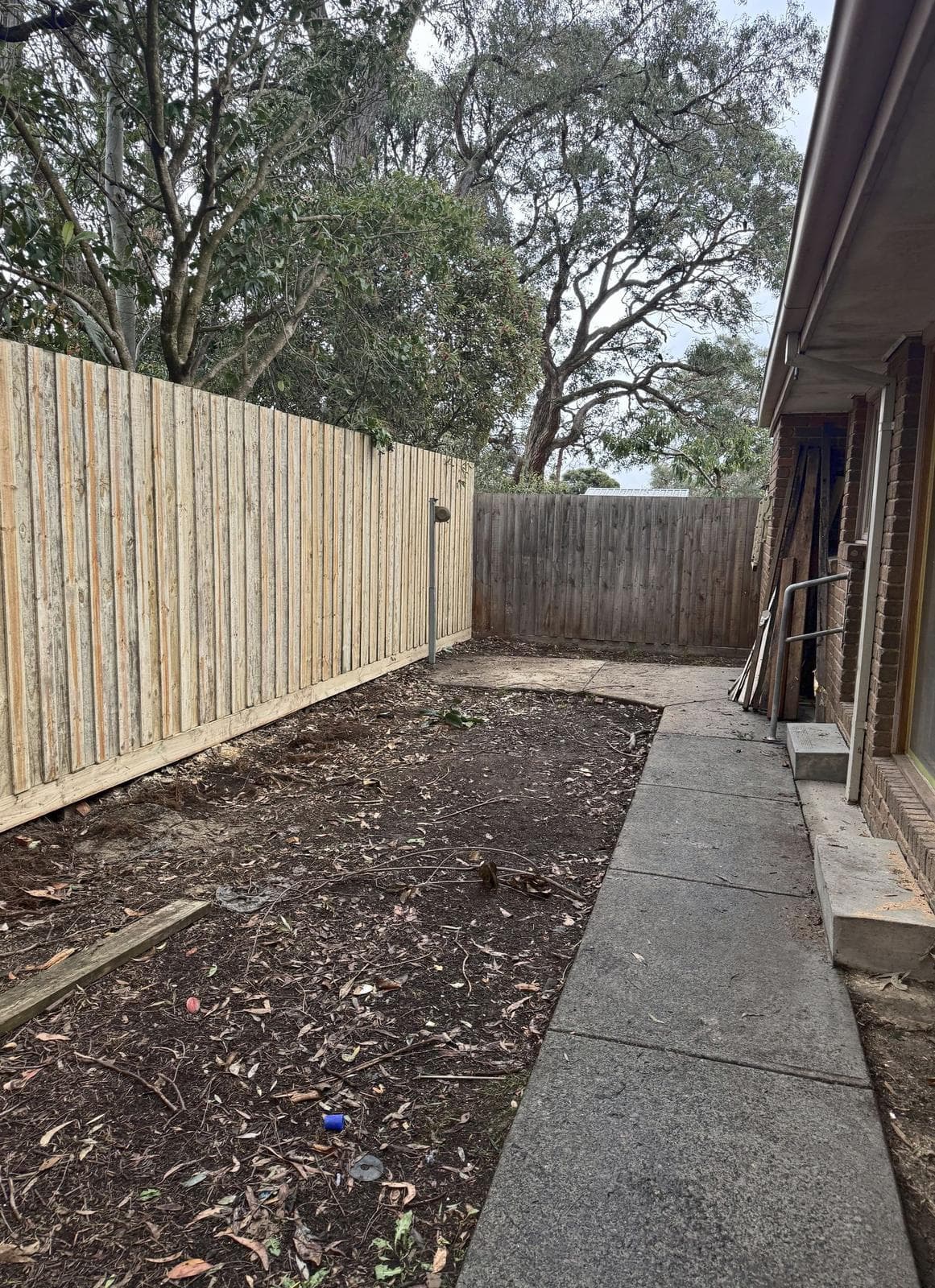 Side yard of bare soil beside a new paling fence before the work, Forest Hill